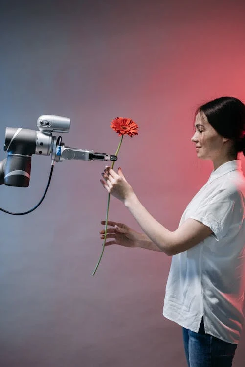 donna che prende un fiore da un robot
