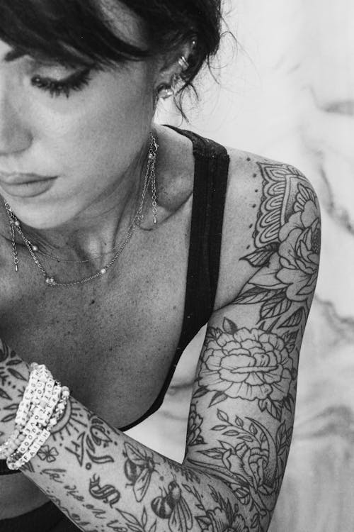 Foto in bianco e nero di una donna con il braccio tatuato in primo piano