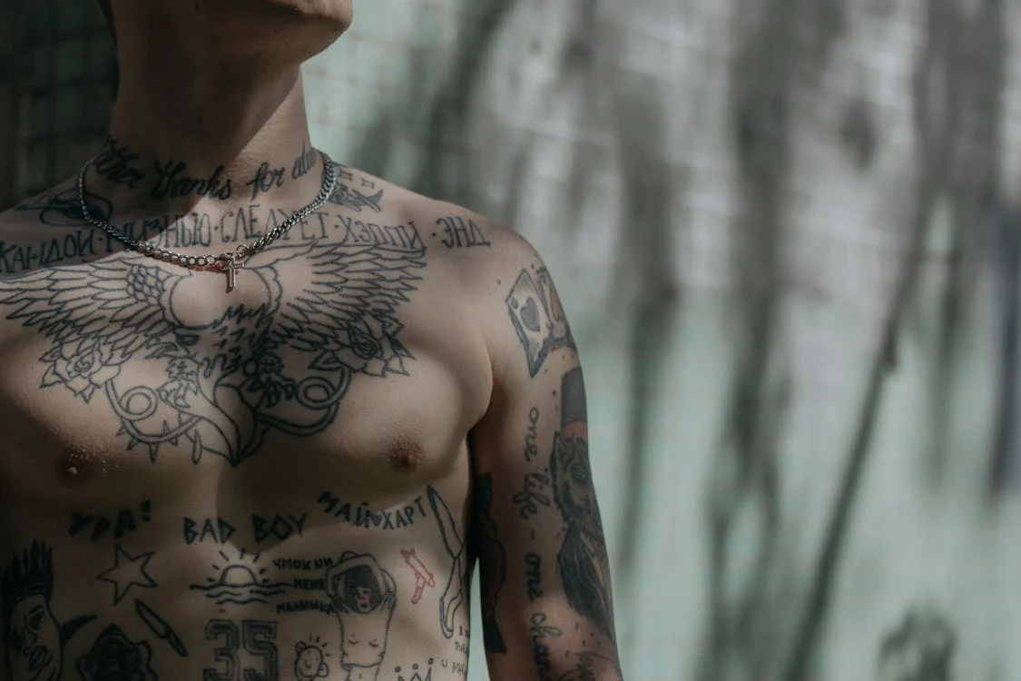 Foto del petto di un uomo ricoperto da tatuaggi