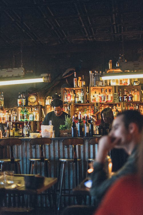 Foto di un bar con un ragazzo dietro il bancone che prepara qualcosa