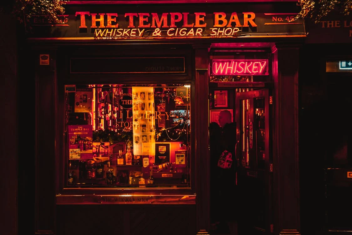 Foto di un bar da fuori con scritte luminose