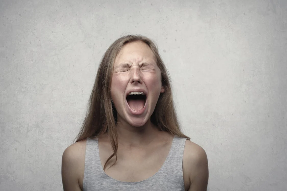 Foto di una ragazza intenta a gridare