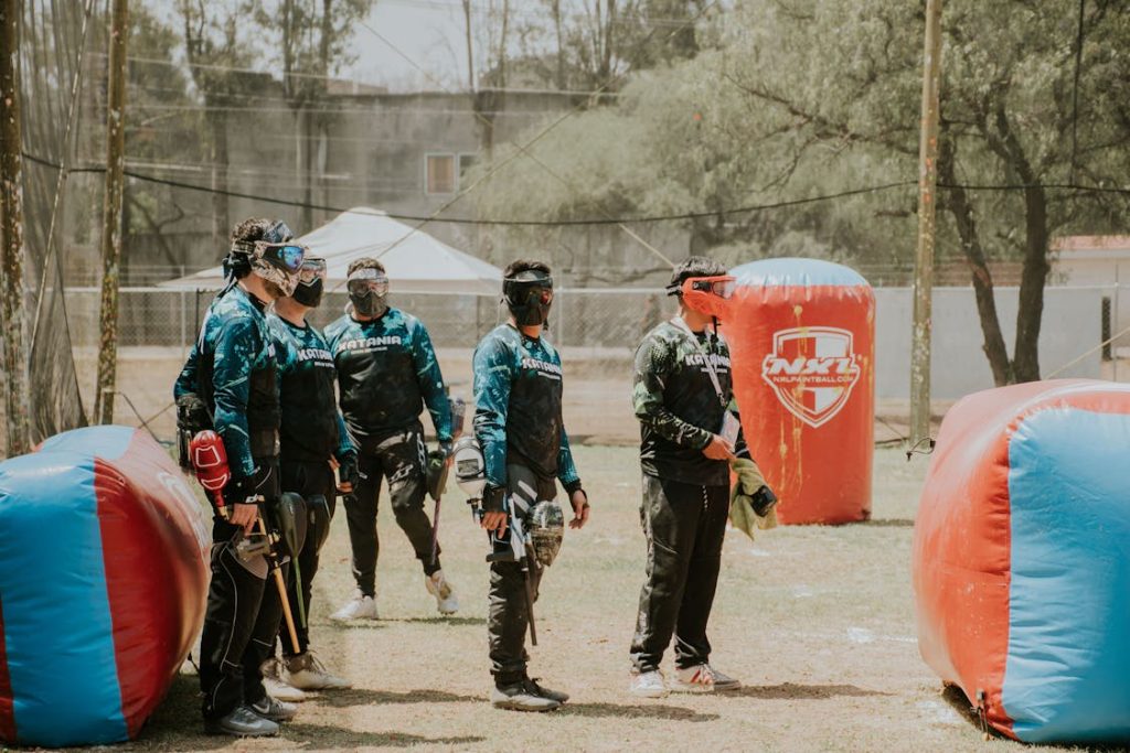 Foto di un gruppo di persone in un campo da paintball intenti a giocare