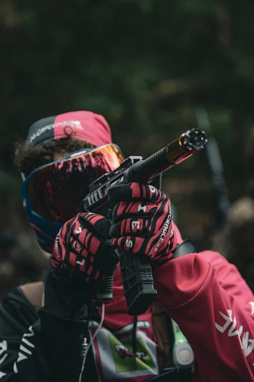 Foto di un ragazzo con un marcatore da paintball puntato