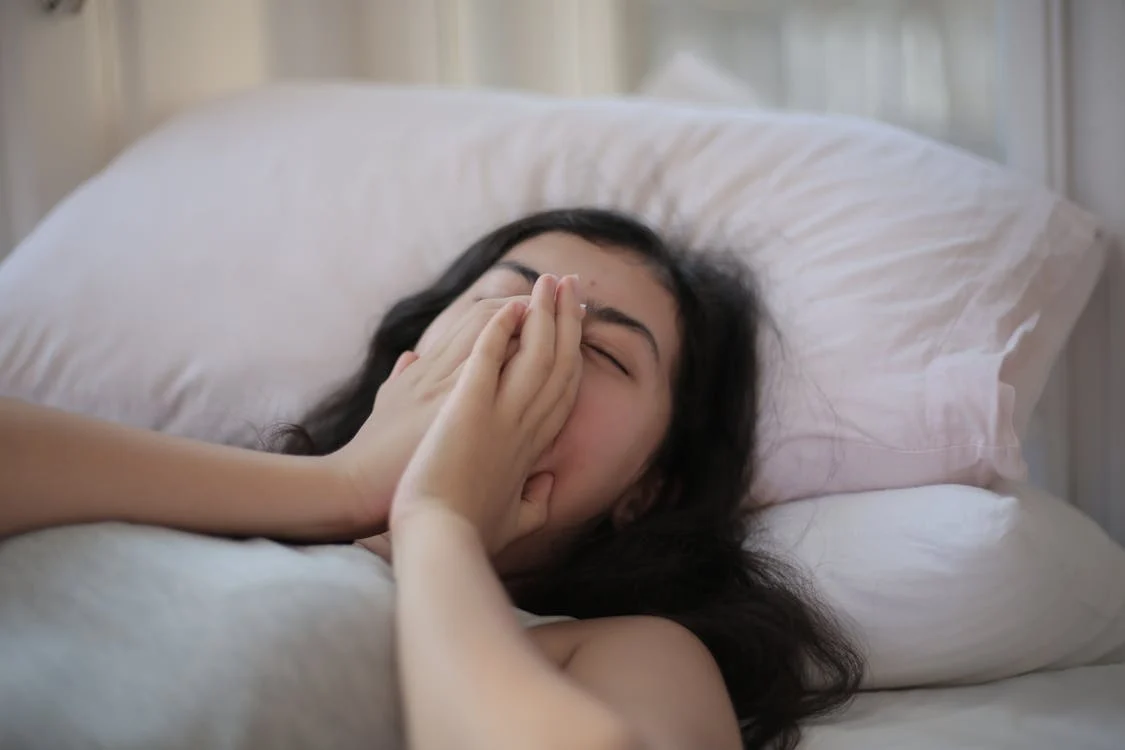 Foto di una ragazza che dorme con le mani in faccia