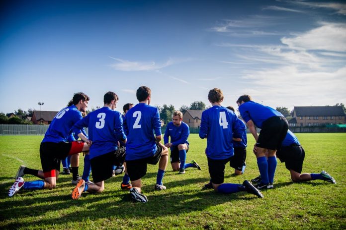 Foto di un gruppo di giocatori di calcio in ginocchio sul campo